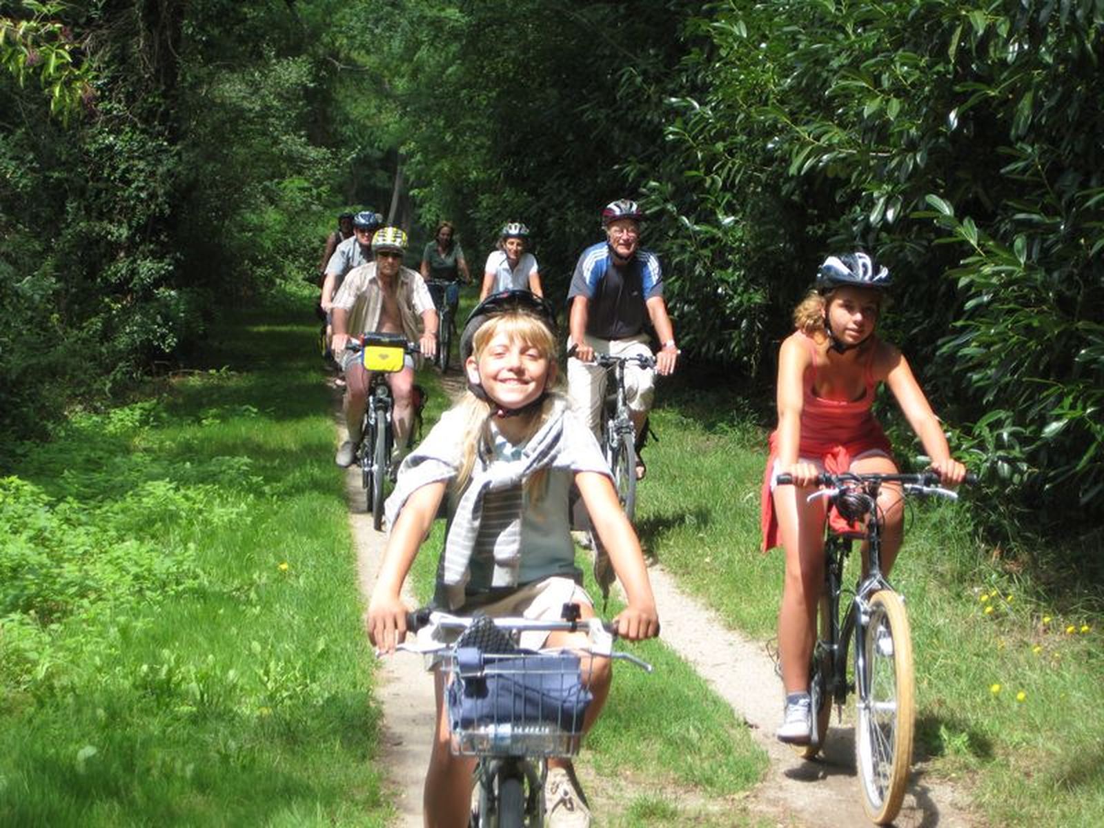 enfants et adultes à vélo sur un chemin de terre